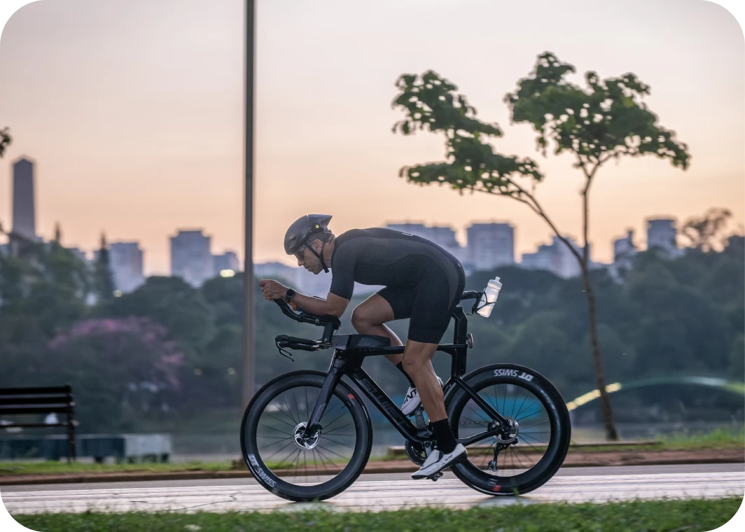 Triatleta pedalando ao amanhecer em um parque urbano
